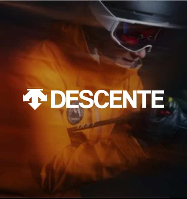 Skifahrer mit orangefarbener Jacke und Descente Logo
