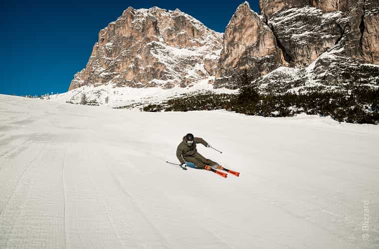 Skifahrer auf Piste mit Bergen im Hintergrund