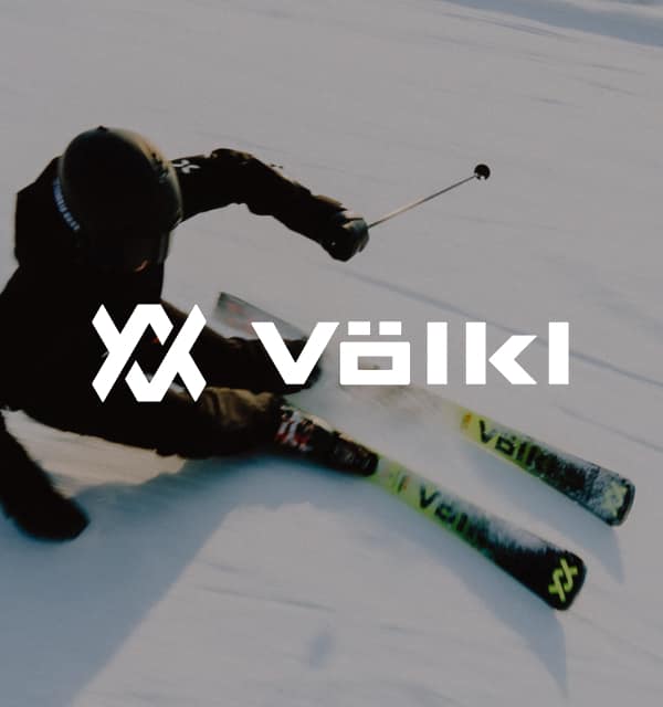 Skifahrer*in auf einer Piste und Völkl Logo